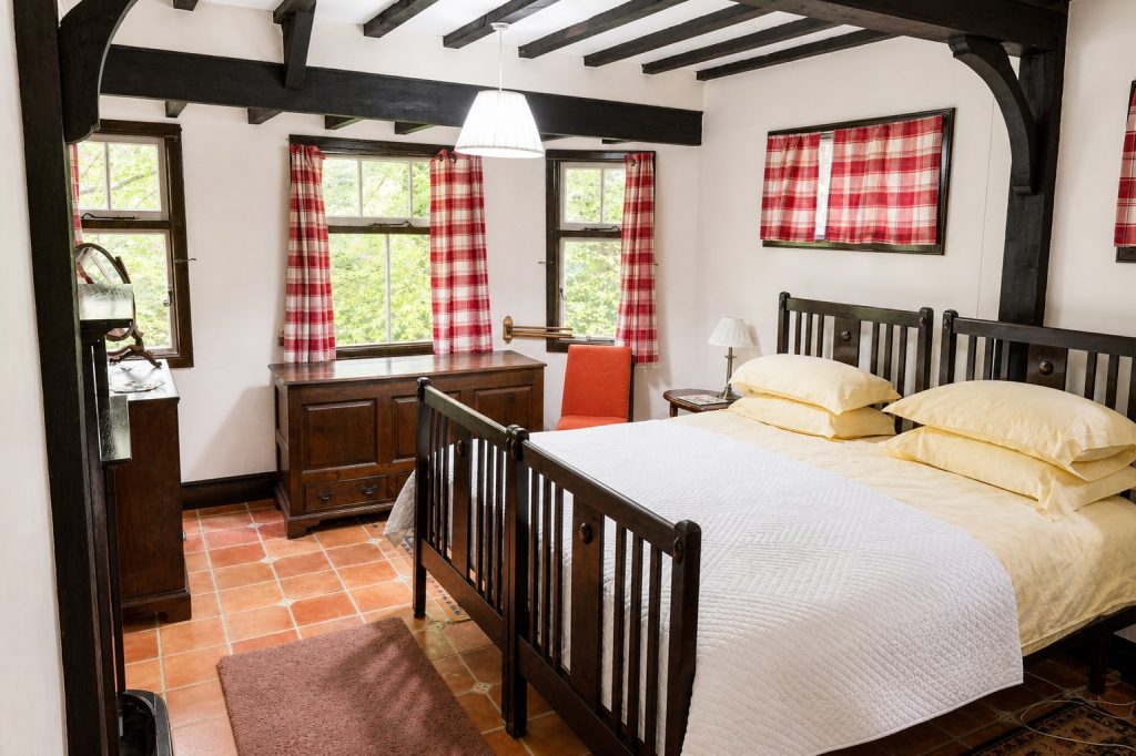 Large double bedroom at Windy Gap with king-size bed and washbasin, overlooking woodland
