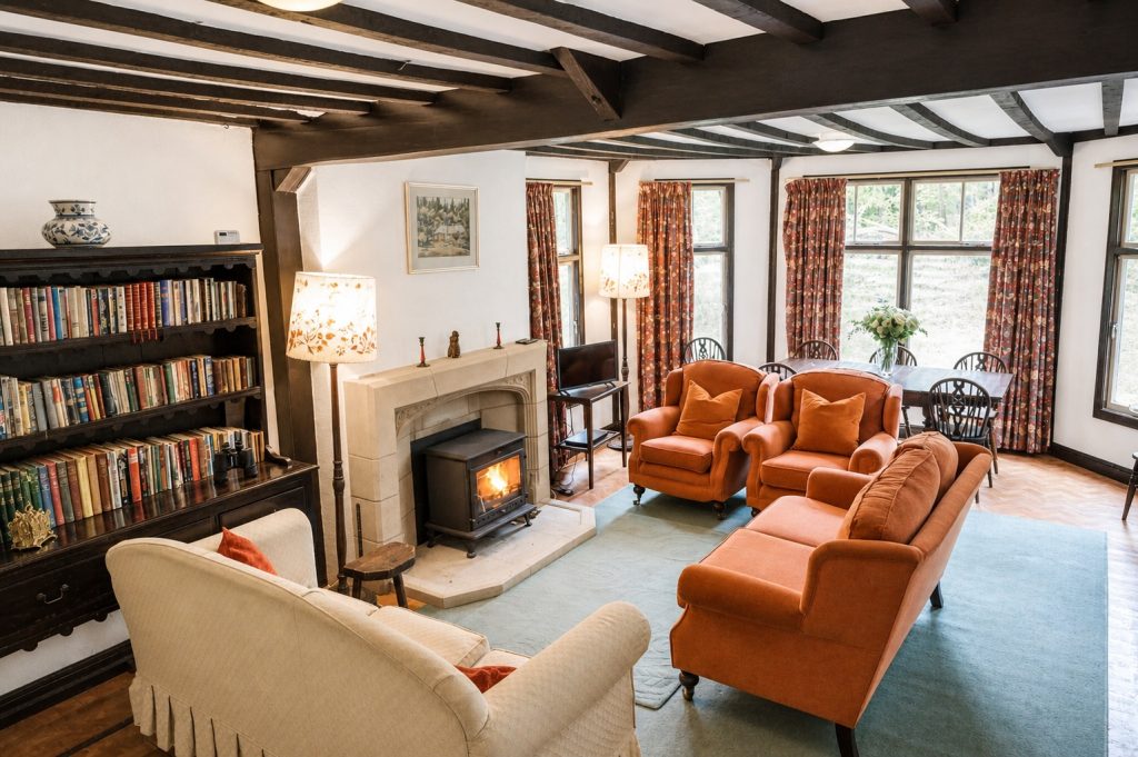 Large living room with woodburner, seating for 8, plus dining table, overlooking lawn and woodland