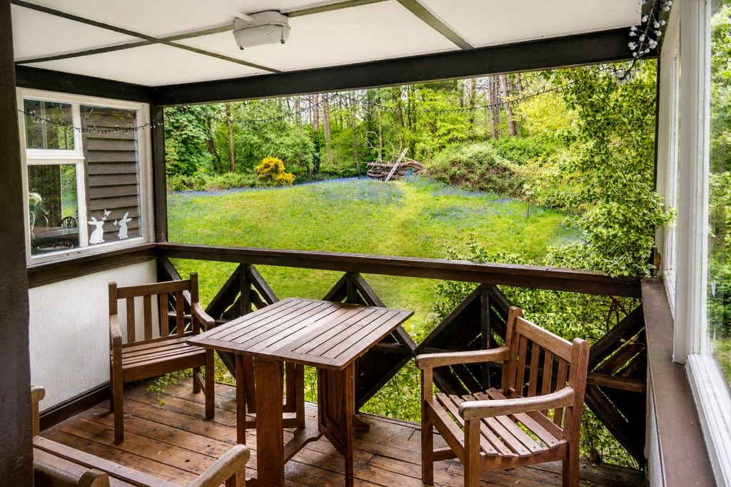 South-facing glazed veranda at Windy Gap with sliding doors overlooking private woodland